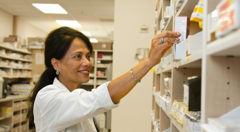 woman in white coat shirt holding medicine box